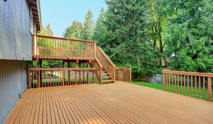 spacious redwood deck with stairs going to the upper deck overlooking the woods