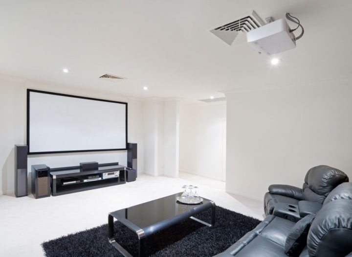 Modern bright home theater Room with black leather recliner chairs